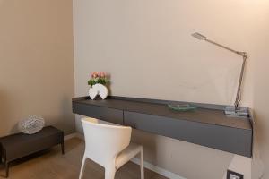 a desk in a room with a white chair at Deluxe apartment Milia Agrigento in Agrigento