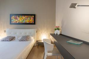 a bedroom with a white bed and a desk with a chair at Deluxe apartment Milia Agrigento in Agrigento