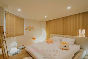 - une chambre dotée d'un lit avec des animaux rembourrés dans l'établissement Mini Jung Karaksa, à Chiang Mai
