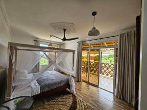 ein Schlafzimmer mit einem Himmelbett in der Unterkunft Ras Kitao Holiday Villa in Lamu