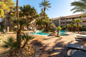 a courtyard with a swimming pool with palm trees at Stylish, Cozy 2BR,2BA Condo near Rio, Vegas Luxury in Las Vegas