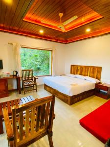 ein Schlafzimmer mit einem großen Bett und einem Fenster in der Unterkunft kurinjiyil Farm Stay Munnar in Munnar