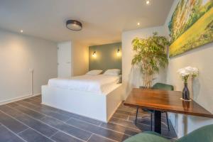 - une chambre avec un lit blanc et une table en bois dans l'établissement Fletcher Hotel-Restaurant Waalwijk, à Waalwijk