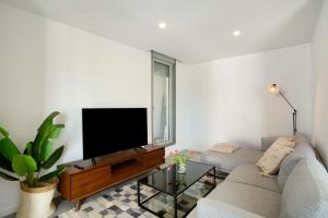 a living room with a couch and a flat screen tv at Penthouse Aliseo on the beach in Las Palmas de Gran Canaria