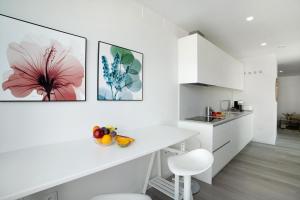 a kitchen with white cabinets and a white counter top at Penthouse Aliseo on the beach in Las Palmas de Gran Canaria