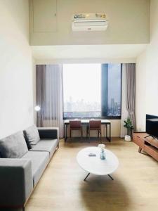 a living room with a couch and a table at Ramada素坤逸87 Loft 空中酒吧 高层景观 BTS On Nut in Bangkok