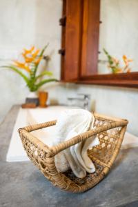 a basket filled with towels on a bathroom sink at New Mangosteen Garden Villa in Hikkaduwa