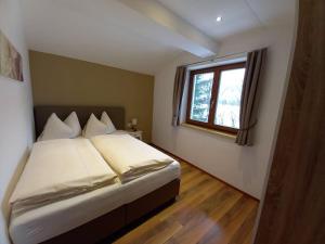 a bedroom with a bed and a window at Ferienwohnung Marlene in Höggen