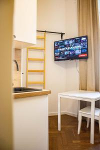 a kitchen with a table and a tv on the wall at Kawalerka w Centrum Warszawy in Warsaw