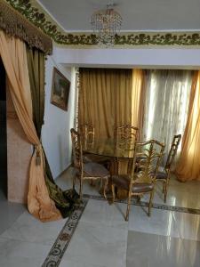 ein Esszimmer mit einem Tisch, Stühlen und einem Kronleuchter in der Unterkunft Luxury 3 rooms Flat in Kairo