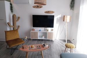 ein Wohnzimmer mit einem TV und einem Couchtisch in der Unterkunft Villa piscine chauffée babyfoot pétanque ping-pong in Bon-Encontre