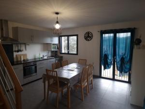 una cucina con tavolo e sedie e una sala da pranzo di Appartement rez de jardin a Saint-Martin-dʼUriage