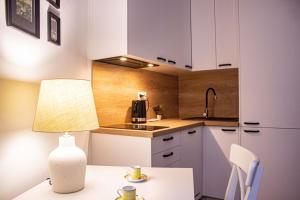 cocina con armarios blancos y mesa con lámpara en Przytulne mieszkanie w Centrum en Varsovia