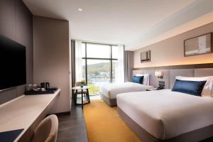 ein Hotelzimmer mit 2 Betten und einem TV in der Unterkunft DoubleTree By Hilton Seoul Pangyo Residences in Seongnam