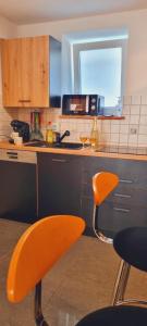 an orange chair in a kitchen with a sink at Fe Wo Auf der Alb 