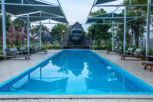 uma piscina com uma estátua ao fundo em Yoko River Kwai Resort em Sai Yok