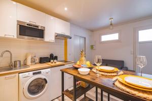 a kitchen with a washing machine and a table with glasses at Pauline's Home Gambetta - Proche Cathédrale - Calme in Reims +11 photos