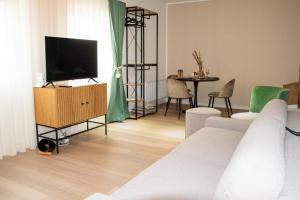sala de estar con sofá blanco y TV en Qonroom - as individual as you - Minden Kaiserstrasse, en Minden