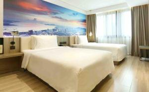 a hotel room with two beds and a painting on the wall at Atour Hotel Shenzhen Nanshan Coast City in Shenzhen