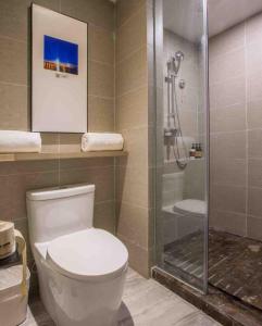 ein Bad mit einem WC und einer Glasdusche in der Unterkunft Atour Hotel Shenzhen Nanshan Coast City in Shenzhen