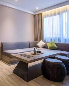 ein Wohnzimmer mit einem Sofa und einem Tisch in der Unterkunft Atour Hotel Shenzhen Nanshan Coast City in Shenzhen