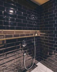 baño con pared de ladrillo negro y ducha en The Drama en Shanghái