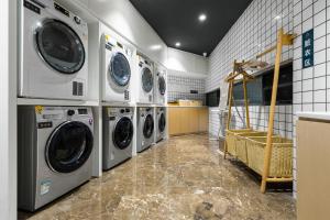 uma lavandaria com quatro máquinas de lavar e secar roupa em Atour Hotel Chongqing Liziba Lianglukou Subway Station em Chongqing