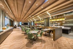 a restaurant with wooden ceilings and tables and chairs at Atour S Hotel Guangzhou Tianhe Taikoo Hui in Guangzhou