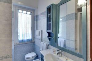 ローマにあるOlimpia Apartmentのバスルーム(洗面台、トイレ、鏡付)