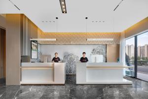 two people standing at a counter in a salon at Atour Hotel Karamay in Karamay