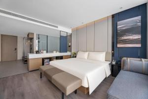 1 dormitorio con 1 cama blanca grande y baño en Atour Hotel Karamay en Karamay