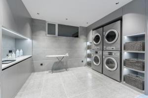 a laundry room with three washing machines and a counter at Atour Light Hotel Dalian Xinghai Plaza Shengya Ocean World in Dalian
