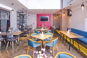 a restaurant with wooden tables and blue chairs at Atour Hotel Qinhuangdao Railway Station Yingbin Road in Qinhuangdao