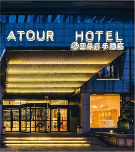 una señal de hotel en la parte delantera de un edificio en Atour Music Hotel Hangzhou West Lake, en Hangzhou