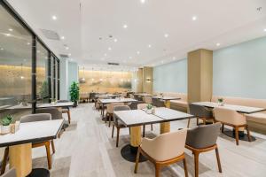 a restaurant with tables and chairs and a large screen at Atour Hotel Xuzhou East Jianguo Road Suning Plaza in Xuzhou +52 photos