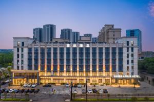 un gran edificio con coches estacionados en un estacionamiento en Atour Hotel Hangzhou Xintiandi Zhongda Intime en Hangzhou