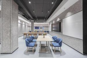 a conference room with a table and blue chairs at Atour Light Hotel Dalian Xinghai Plaza Shengya Ocean World in Dalian