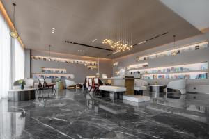 a lobby with tables and chairs in a room at Atour Hotel Karamay in Karamay +14 photos