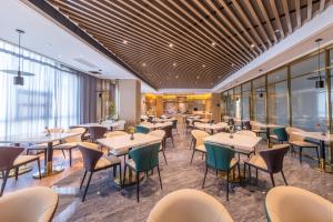 um restaurante com mesas, cadeiras e janelas em Atour Hotel Hefei Pearl Plaza Huijin Business Center em Hefei