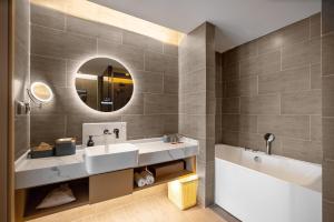 a bathroom with two sinks and a mirror at Atour S Hotel Xining Haihu New District SDIC Plaza in Xining