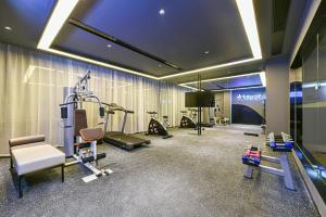 a gym with several treadmills and machines in a room at Atour Hotel Dongguan Nancheng International Trade Center in Dongguan