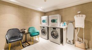 - une buanderie avec un lave-linge et une chaise dans l'établissement Atour Hotel Wuxi Sanyang Plaza, à Wuxi