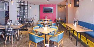un restaurante con mesas de madera y sillas azules en Atour Hotel Qinhuangdao Railway Station Yingbin Road, en Qinhuangdao