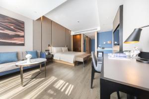 Habitación de hotel con sofá y cama en Atour Hotel Zhuhai Jinwan Gaolan Port, 
