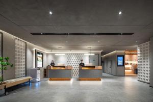 a lobby with two people sitting at a counter at Atour Hotel Anji Longshan in Anji