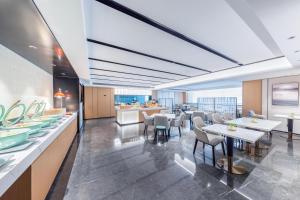 a restaurant with tables and chairs and a cafeteria at Atour Hotel Jinan Shungeng Covention and Exhibition Center Bayi Overpass in Jinan