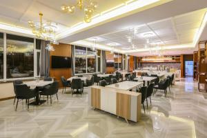 un restaurante con mesas y sillas en una habitación en Atour Hotel Harbin Songbei Ice and Snow World, en Harbin