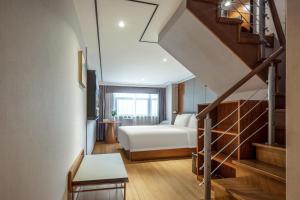 une chambre d'hôtel avec un lit et un escalier dans l'établissement Atour X Hotel Shanghai Lujiazui Binjiang Avenue, à Shanghai