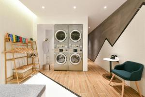 a laundry room with three washing machines and a staircase at Atour Hotel Beijing Wangjing Science and Technology Park in Beijing