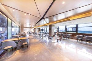 a restaurant with tables and chairs and windows at Atour Hotel Guiyang Guanshan Lake Park in Guiyang